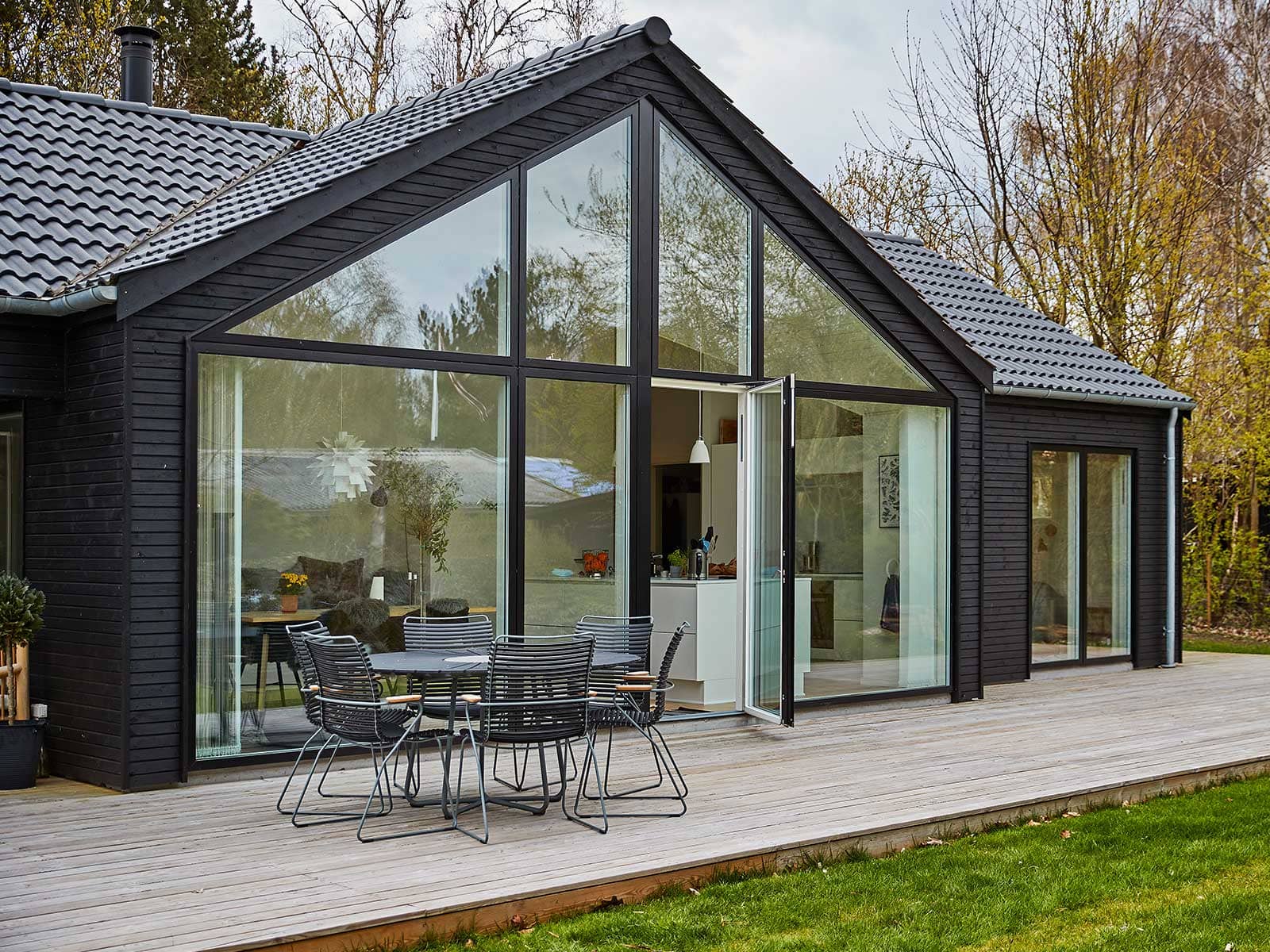Moderne sommerhus med stort glasparti og terrasse.