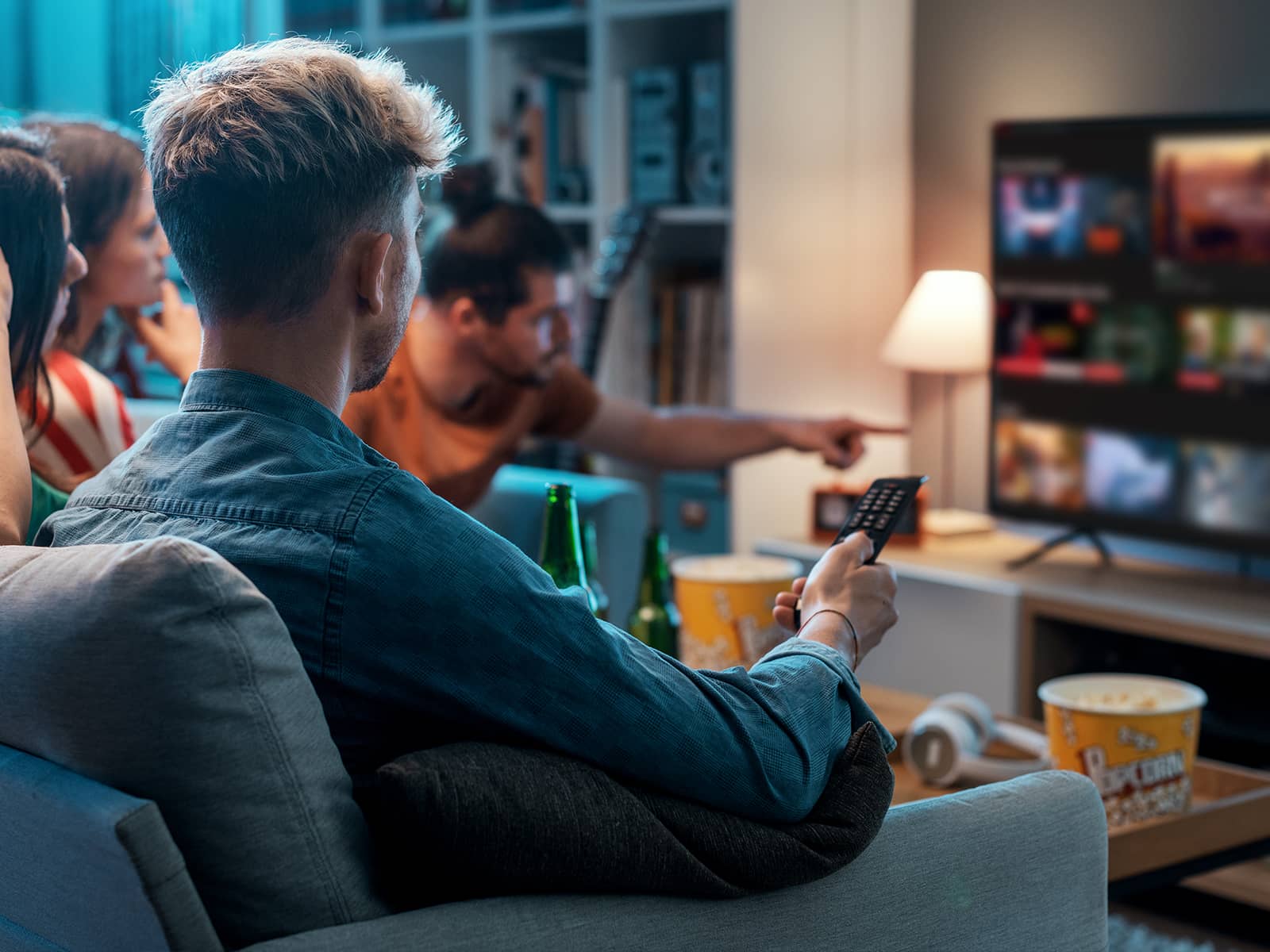 Venner sidder i sofa og ser tv