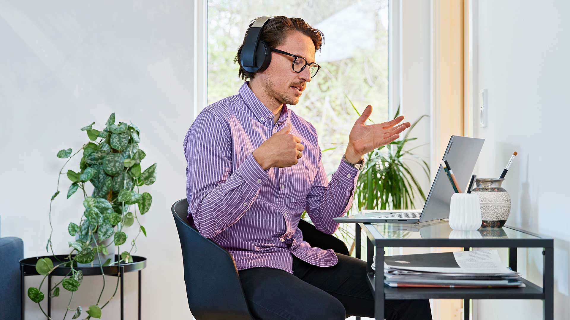 Mand i lilla skjorte deltager i online møde fra hans hjemmekontor