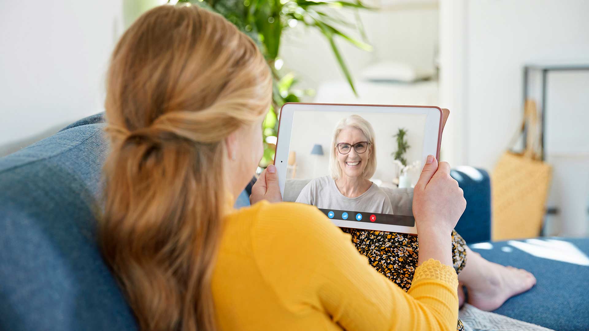Pige facetimer med sin bedstemor. Hun har det bedste bredbånd til hjemmet; fiberbredbånd. Med trådløst internet i hjemmet kan hun lave videoopkald via bredbånd.