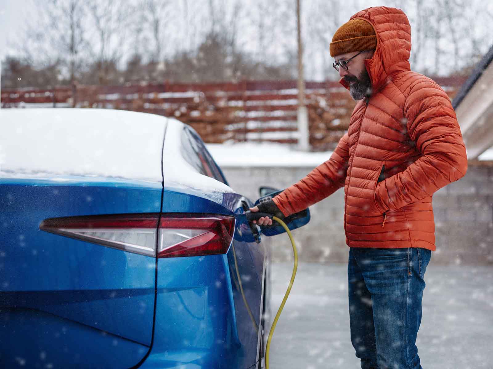 Mand lader elbil om vinteren