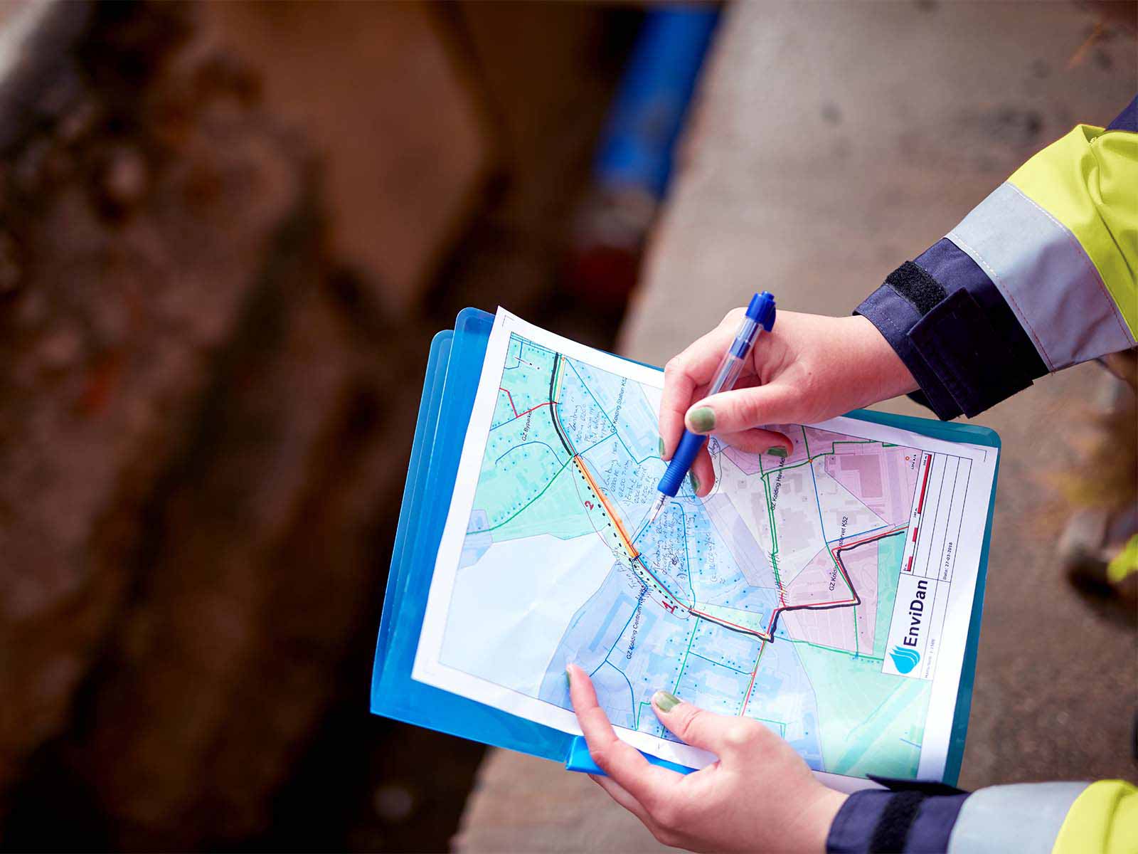 Hænder holder på kort over vandrenoveringsprojekt