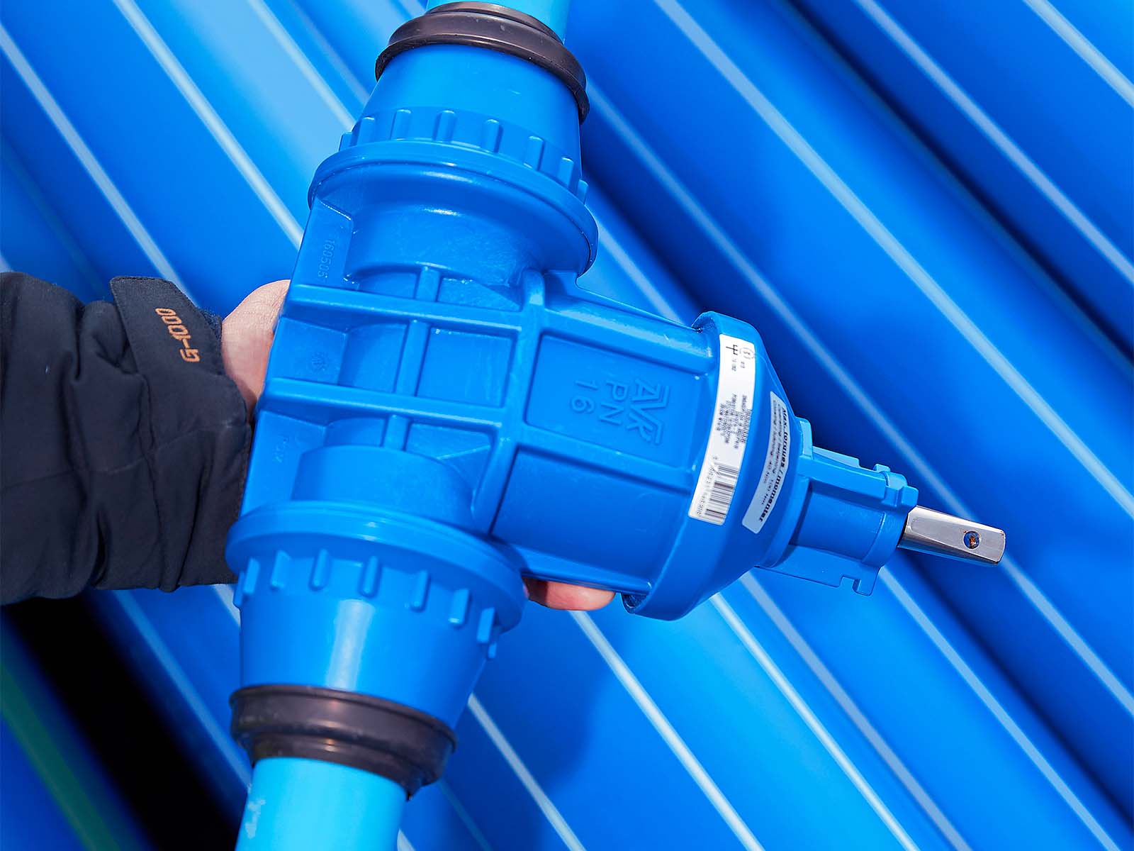 Hånd holder blå vandrør