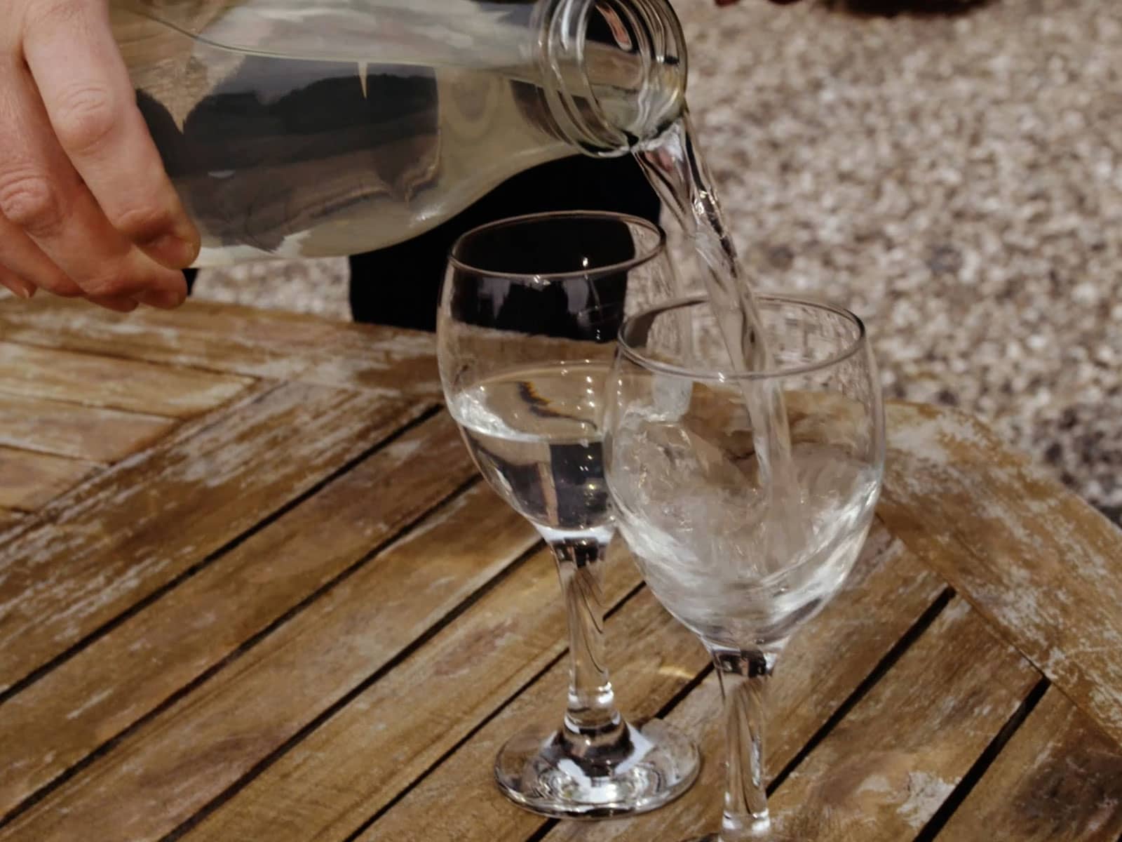 Vand skænkes i glas. 