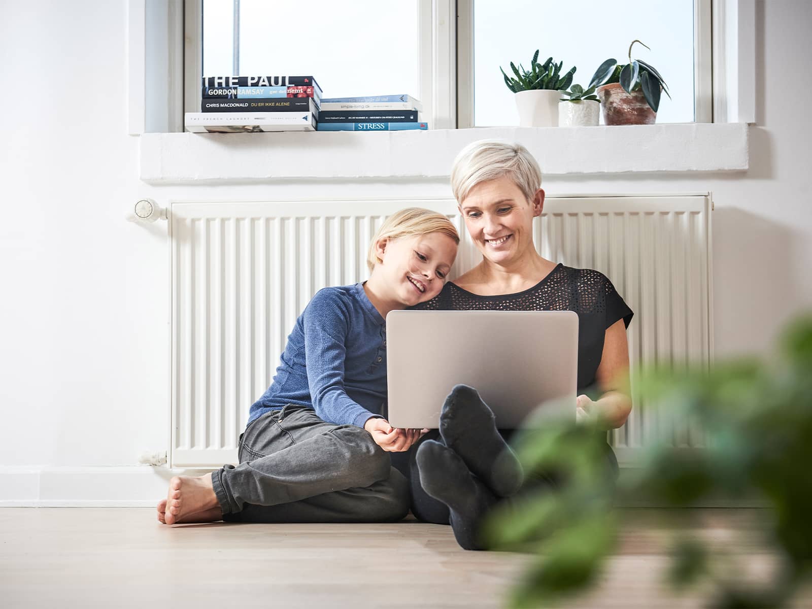 Mor og søn med pc foran radiator