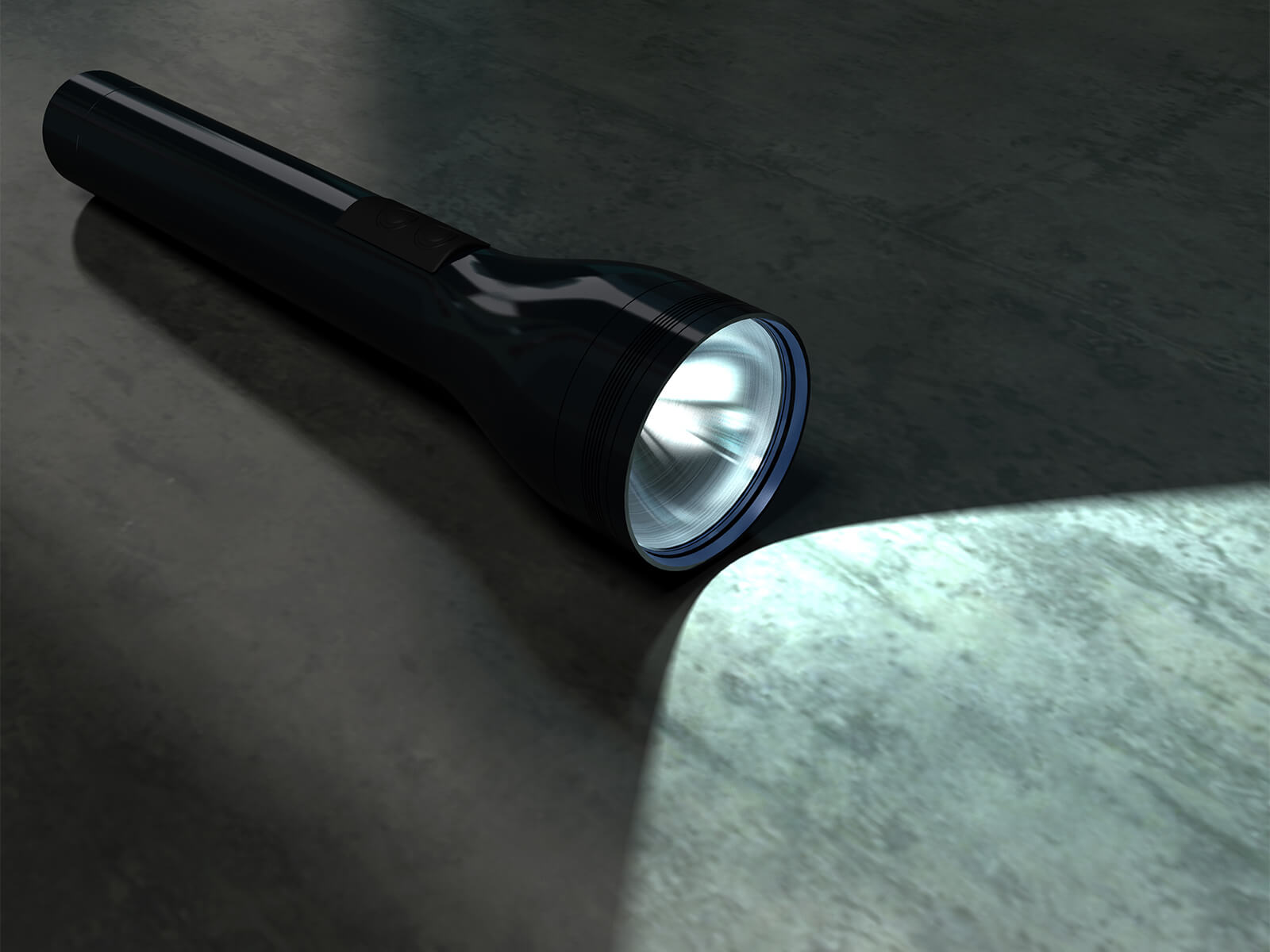 Lommelygte ligger på gulvet i mørke og lyser.