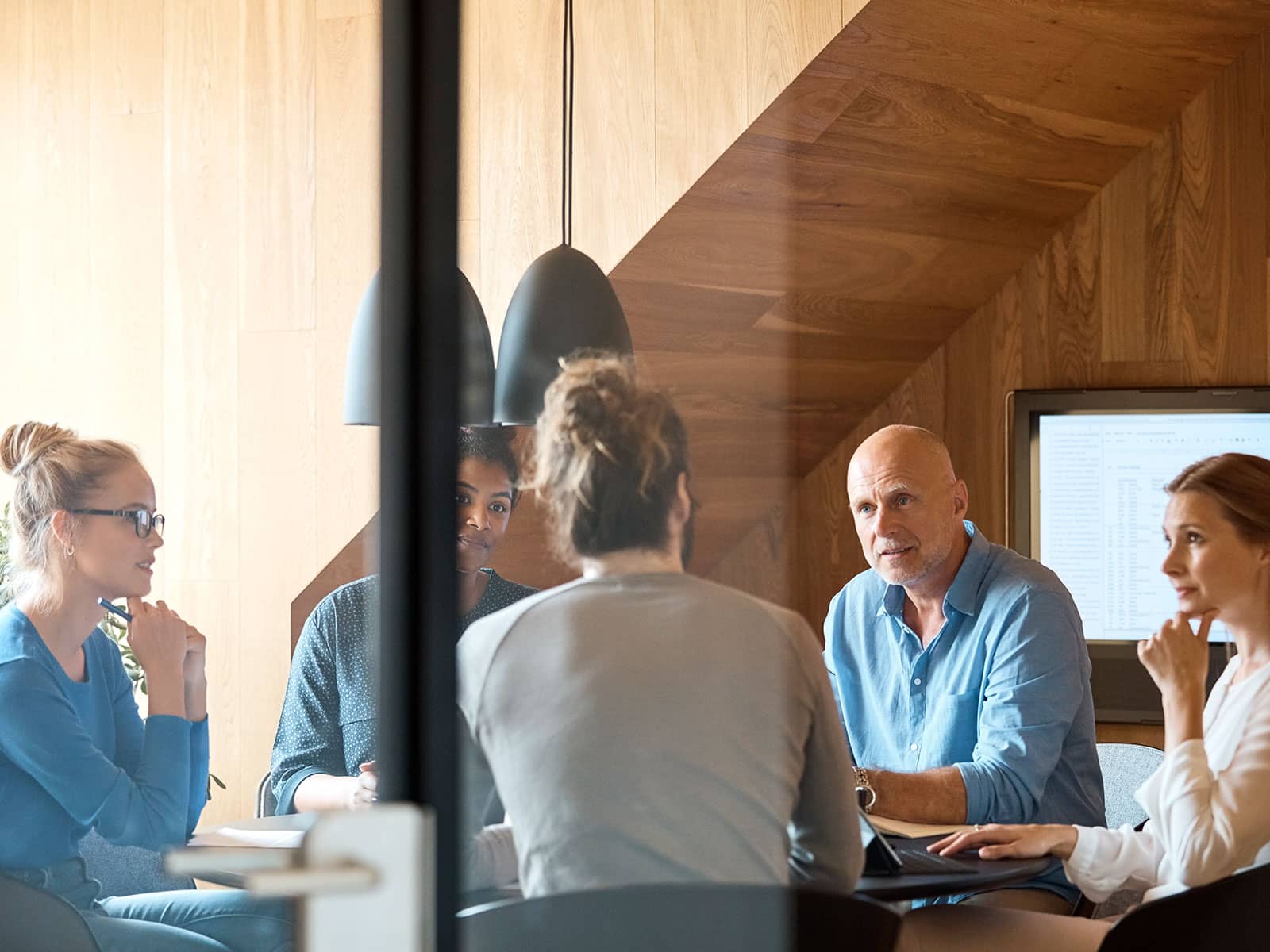 Medarbejdere i mødelokale. Grøn opvarmning til erhverv