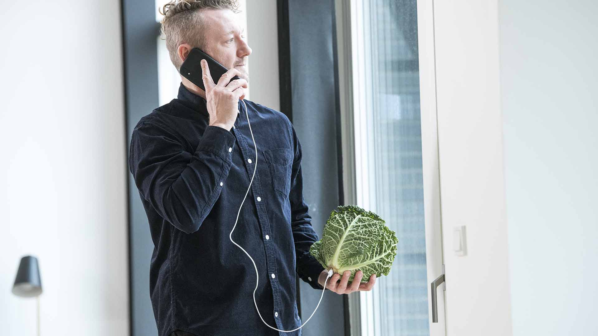 Man on the phone powered by a cabbagehead. EWII is a Danish energy group working with electricity, drinking water, district heating, internet, and charging stations.
