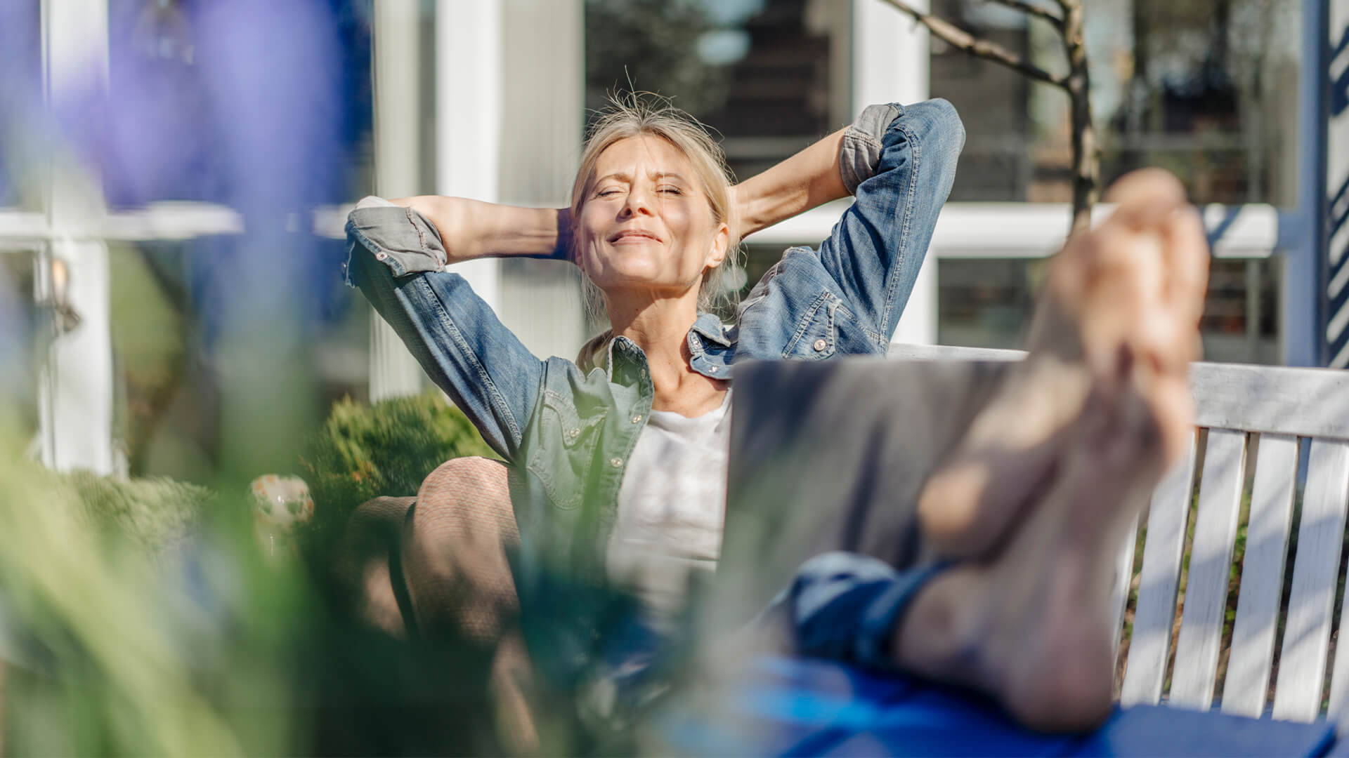 Kvinde nyder solen på en bænk
