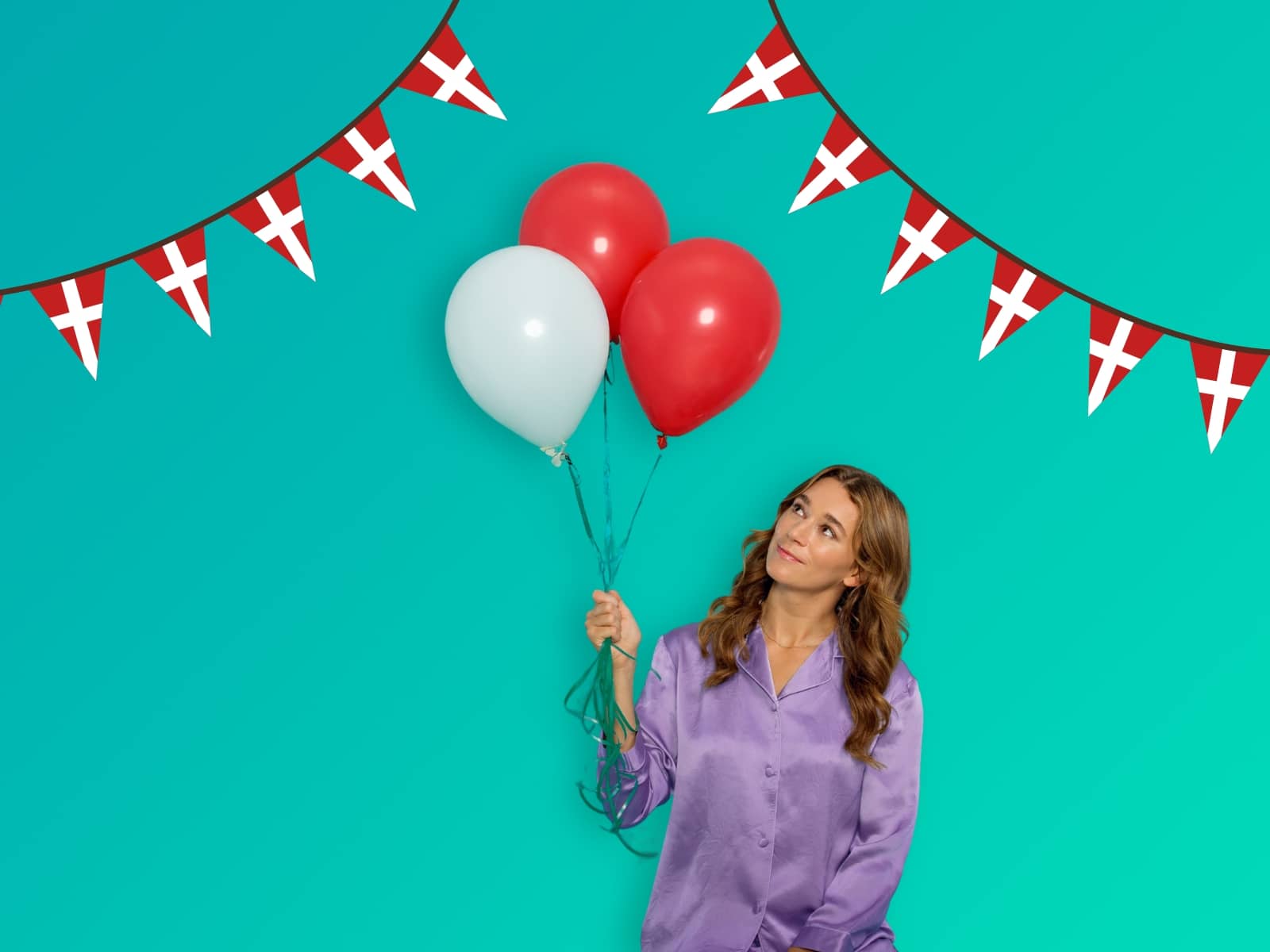 Kvinde i lille pyjamas sidder med en stak røde og hvide balloner i hånden