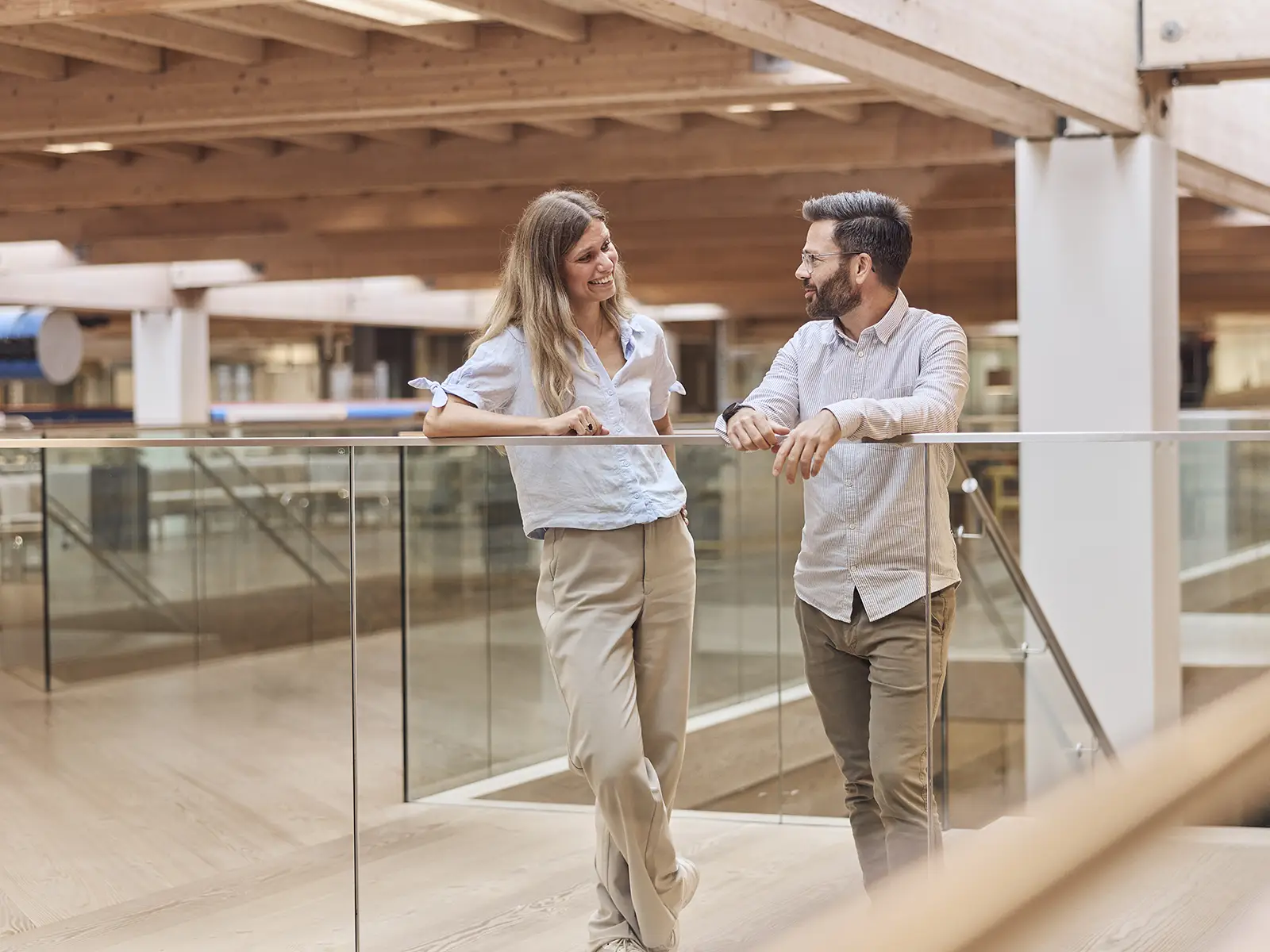 Kvinde og mand ansat i EWII i stående samtale på gang