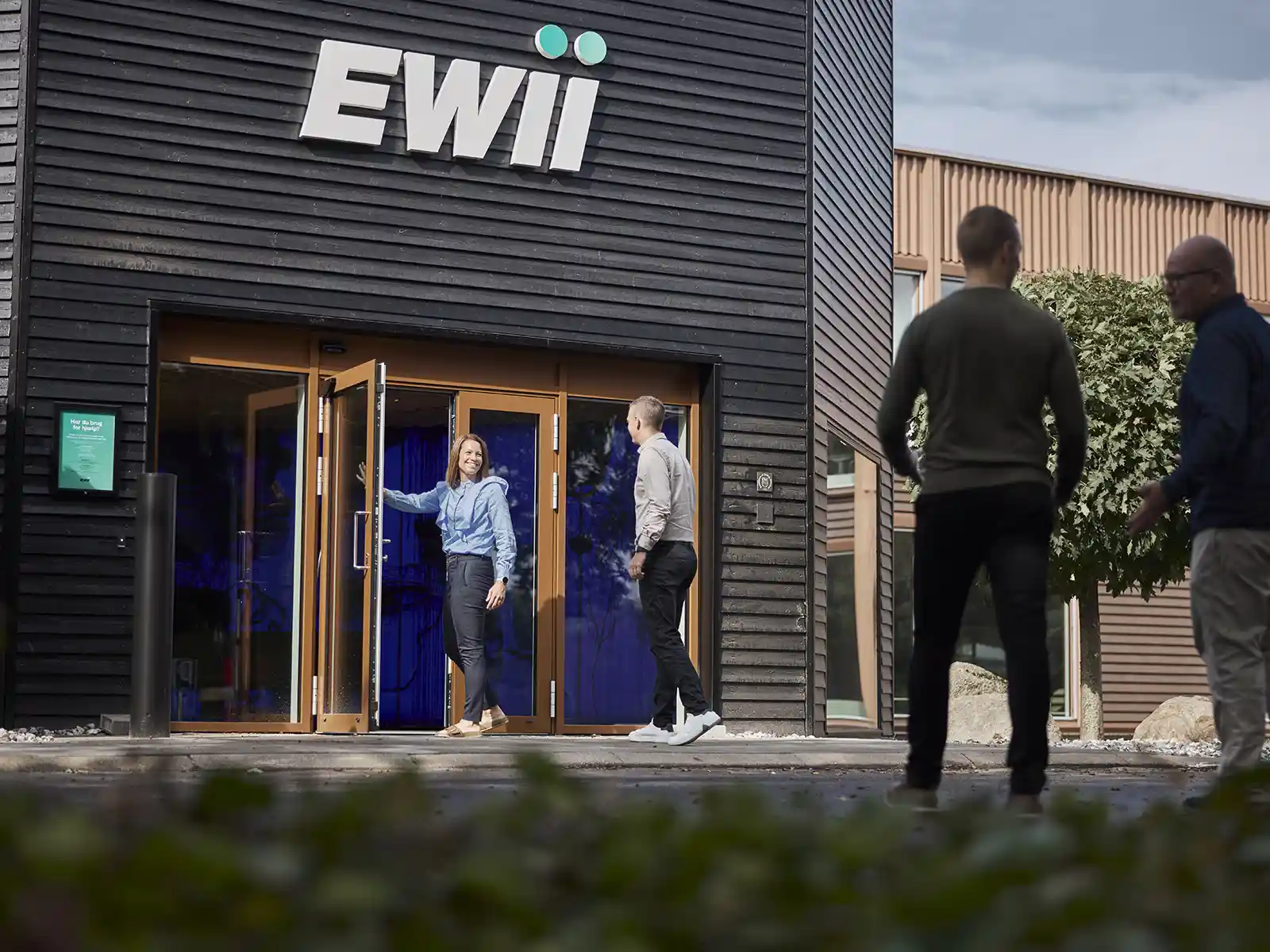 Fire personer ses ved indgangen til EWII på Birkemosevej