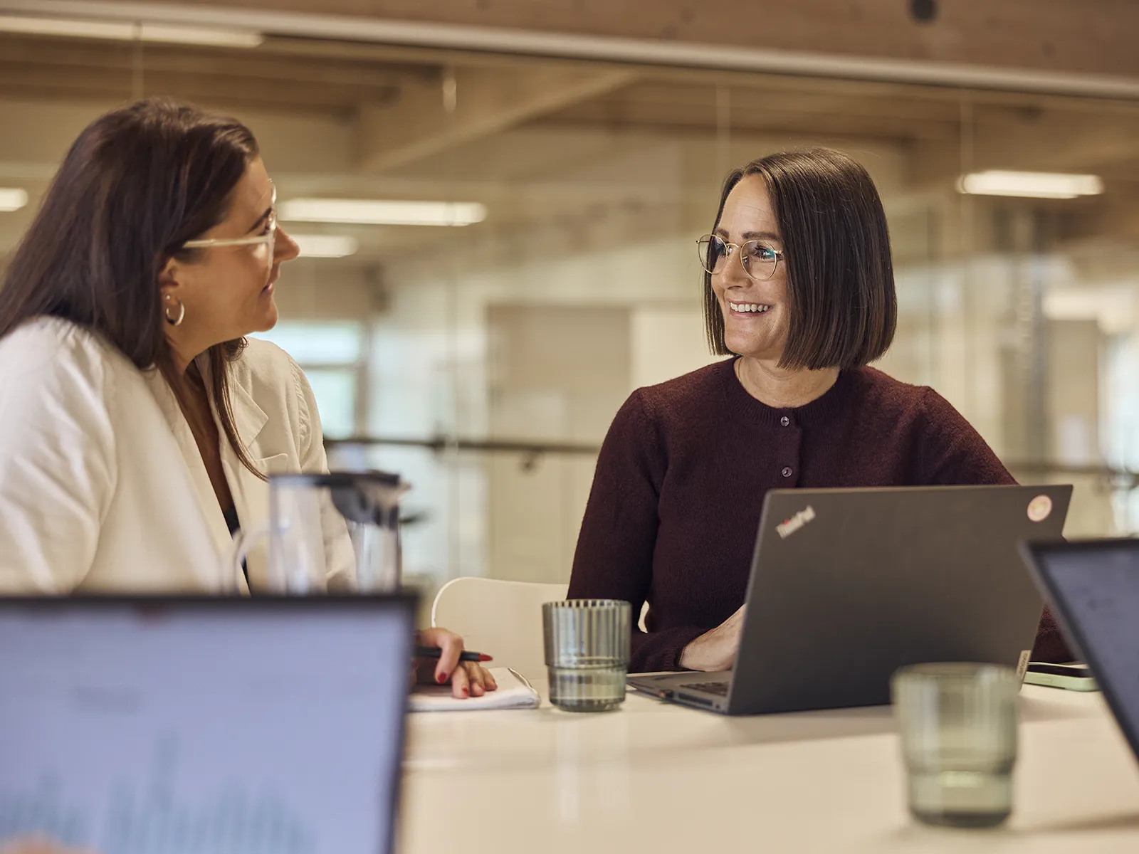To kvindelige EWII kolleger i samtale ved højbord