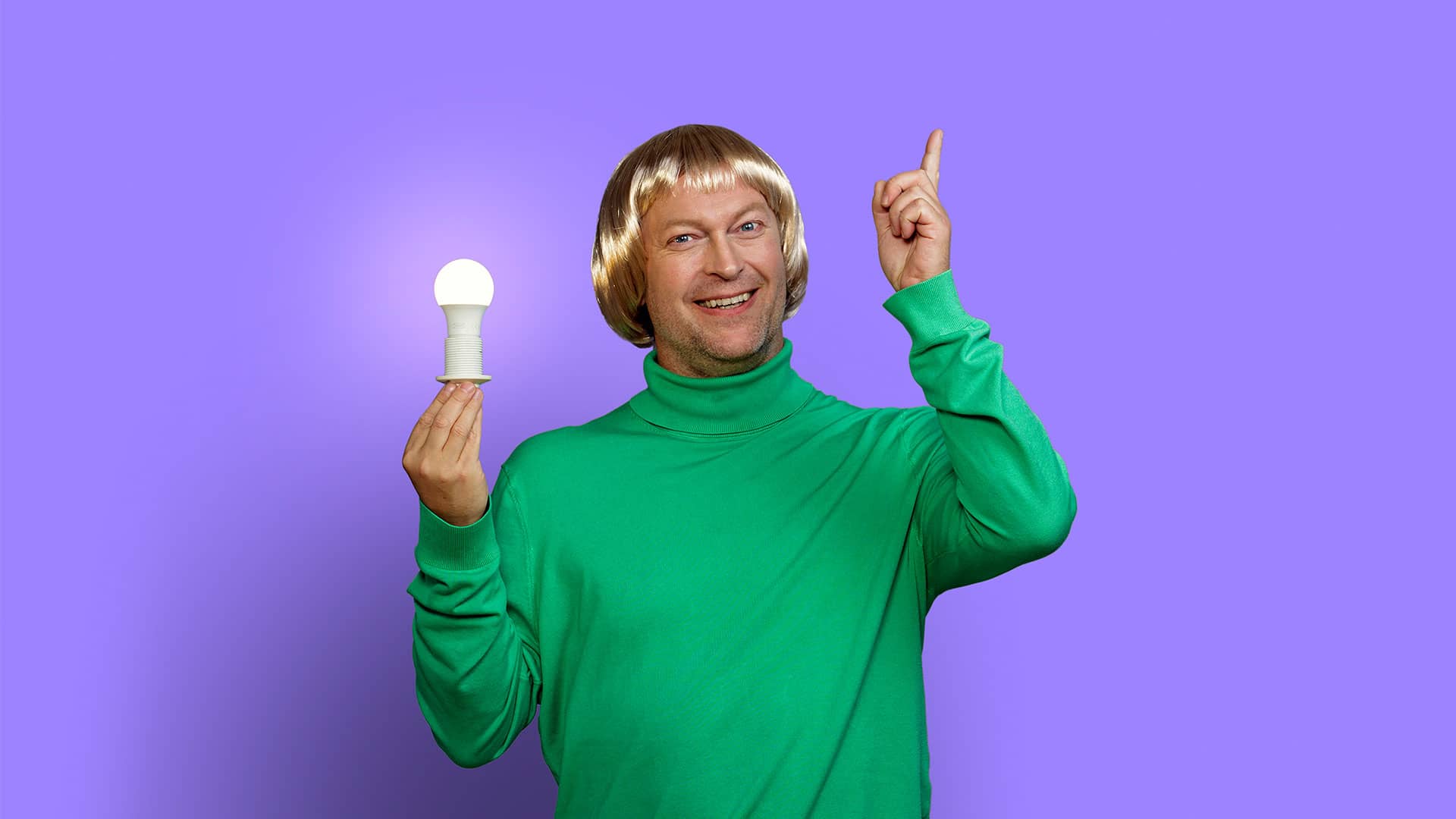 En mand holder en tændt elpære i den ene hånd og peger op i luften med den anden hånd