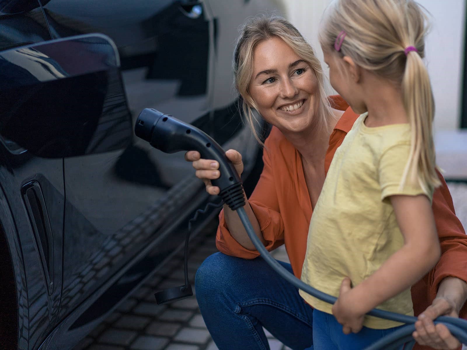Mor og datter lader elbilen med billig grøn el til timepris, som fastsættes hver time. Således betaler hun altid for den aktuelle spotpris på el. 