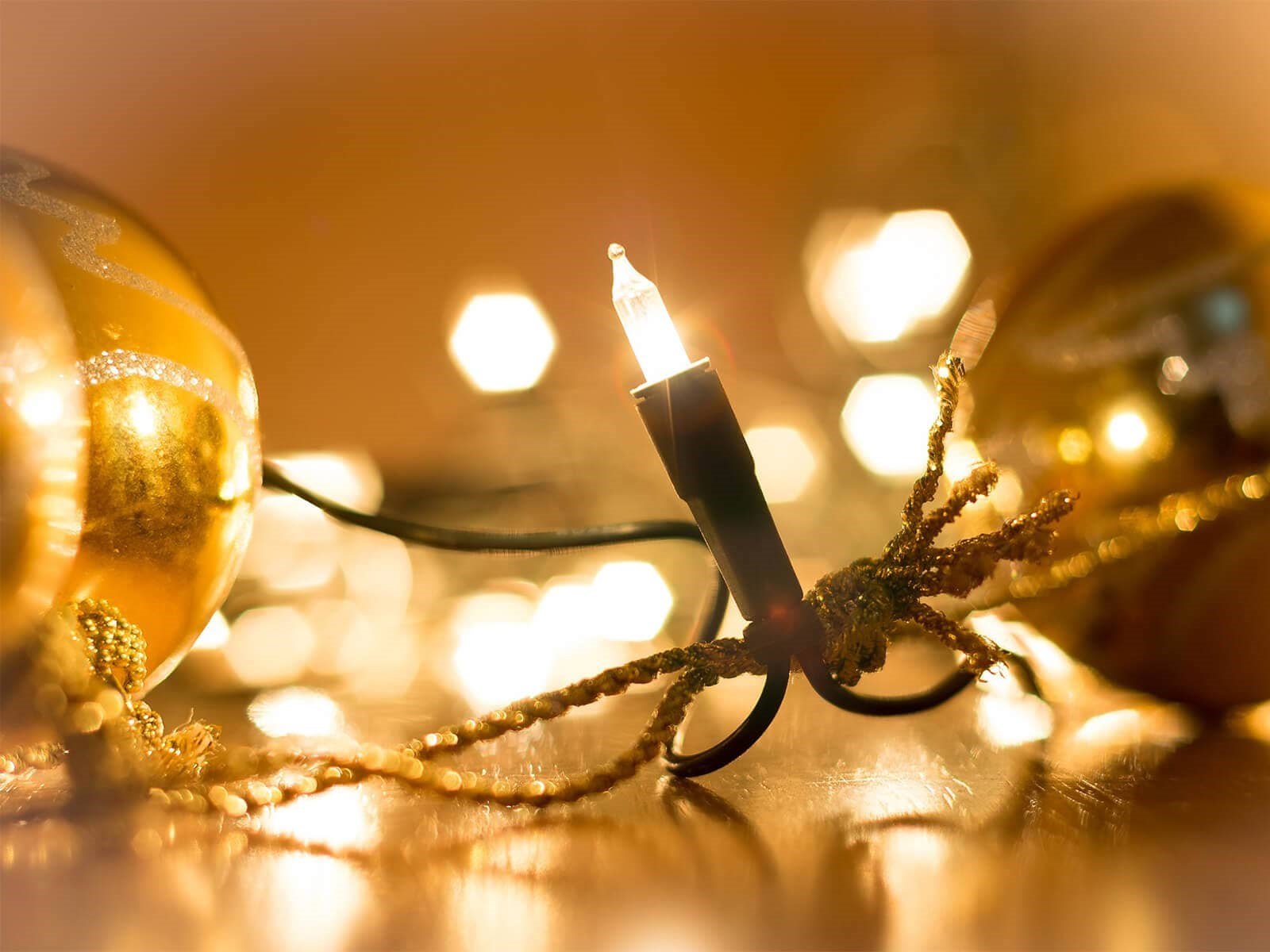 Julekæde med varmt lys ved guldfarvet julekugler