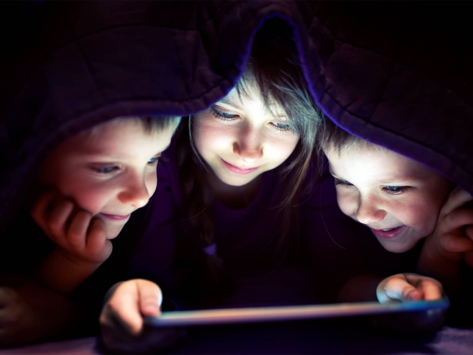 Børn ser film på ipad under dyne, fordi de har en hurtig HGW5 wifi router. Routeren er bedst i test og er den bedste wifi router til dit fiberbredbånd.