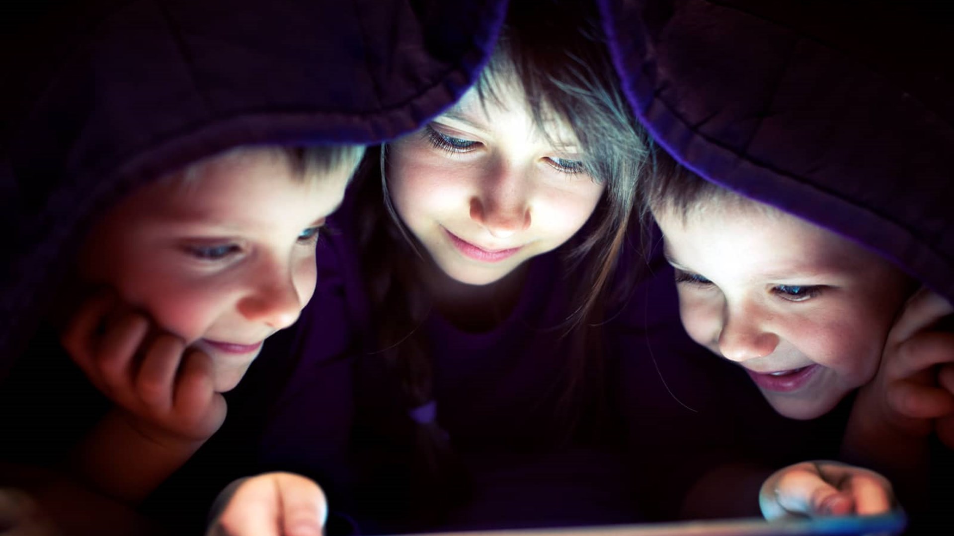 Børn ser film på ipad under dyne, fordi de har en hurtig HGW5 wifi router. Kåret som bedste router til fiber.