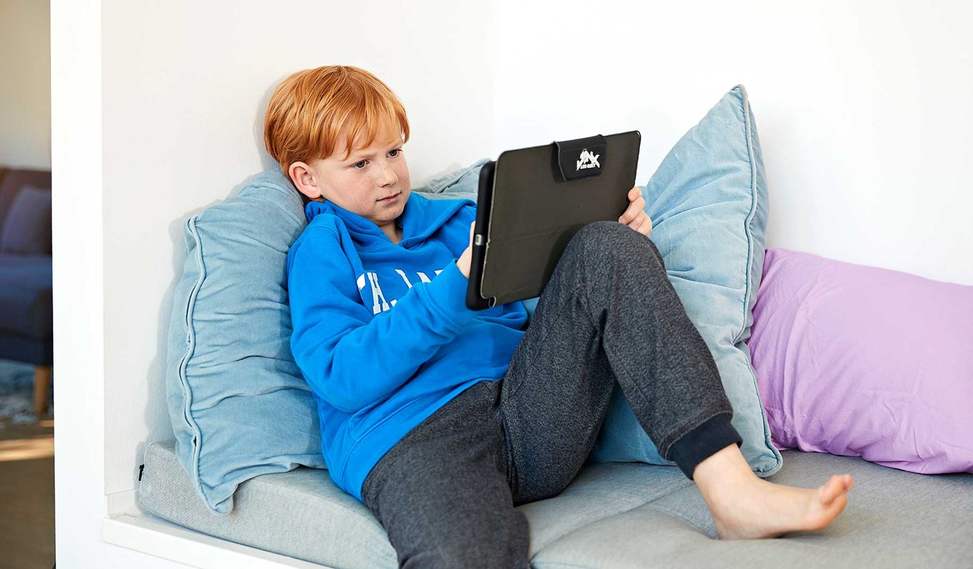 Dreng sidder med ipad. Han bruger trådløst internet. Hvordan får man hurtigere internet og særligt hurtigere trådløst internet? Se 7 tips her.