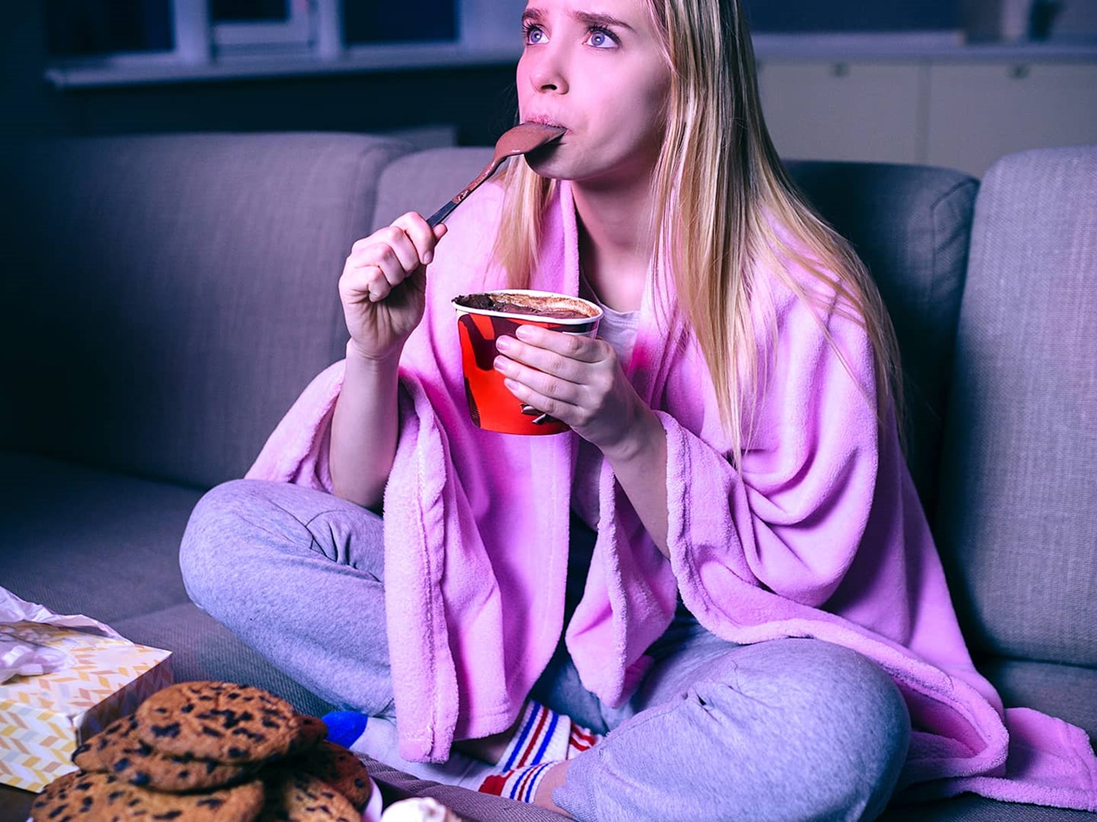 Kvinde streamer og spiser foran tv