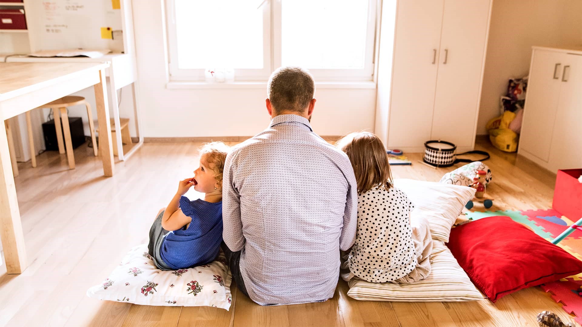 Far og børn ser ipad på gulvet