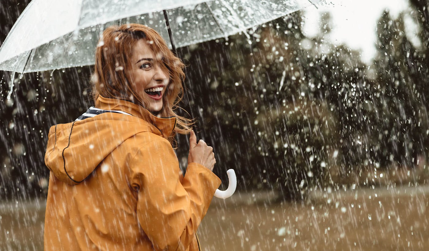 Kvinde med paraply i regnvejr Ansvar for miljøet skal tages alvorligt.